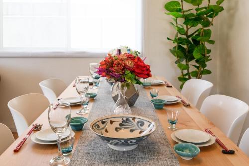 a table with a vase of flowers on top of it at 最大12人築浅物件 南部を満喫したい方に1番のおすすめ宿 無料駐車場3台 サウスウィンドハウス in Inamine