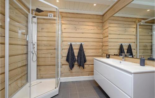 baño con paredes de madera, ducha y lavamanos en Sjusjen Setergrend 4724 B, en Sjusjøen
