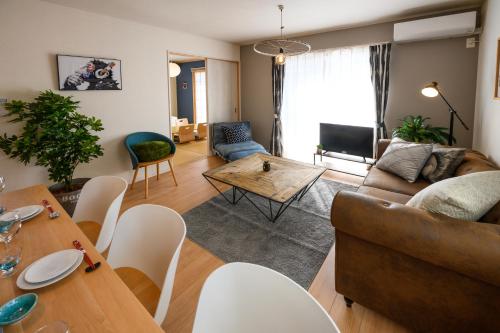 a living room with a couch and a table at 最大12人築浅物件 南部を満喫したい方に1番のおすすめ宿 無料駐車場3台 サウスウィンドハウス in Inamine