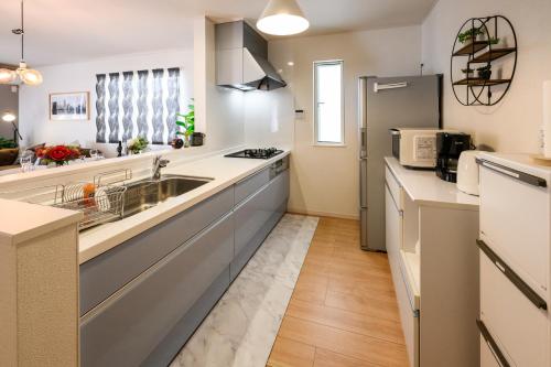 a kitchen with a sink and a refrigerator at 最大12人築浅物件 南部を満喫したい方に1番のおすすめ宿 無料駐車場3台 サウスウィンドハウス in Inamine