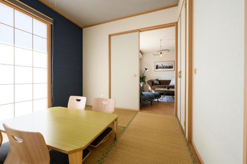 a dining room with a wooden table and chairs at 最大12人築浅物件 南部を満喫したい方に1番のおすすめ宿 無料駐車場3台 サウスウィンドハウス in Inamine