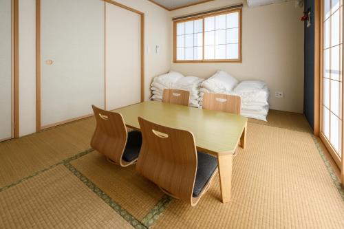 a dining room with a table and chairs at 最大12人築浅物件 南部を満喫したい方に1番のおすすめ宿 無料駐車場3台 サウスウィンドハウス in Inamine