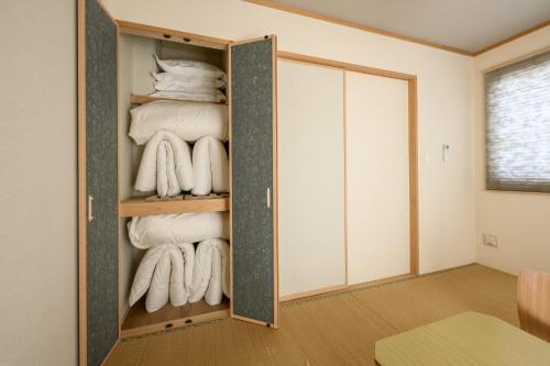 a room with a closet filled with towels at 最大12人築浅物件 南部を満喫したい方に1番のおすすめ宿 無料駐車場3台 サウスウィンドハウス in Inamine