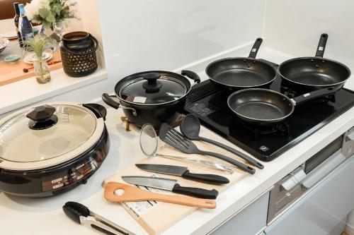 a stove with four pots and pans on it at 最大12人築浅物件 南部を満喫したい方に1番のおすすめ宿 無料駐車場3台 サウスウィンドハウス in Inamine
