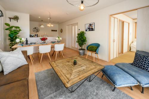 a living room with a couch and a table at 最大12人築浅物件 南部を満喫したい方に1番のおすすめ宿 無料駐車場3台 サウスウィンドハウス in Inamine