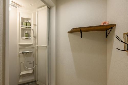 a bathroom with a white door and a refrigerator at 最大12人築浅物件 南部を満喫したい方に1番のおすすめ宿 無料駐車場3台 サウスウィンドハウス in Inamine