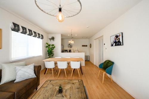 a living room with a couch and a table at 最大12人築浅物件 南部を満喫したい方に1番のおすすめ宿 無料駐車場3台 サウスウィンドハウス in Inamine