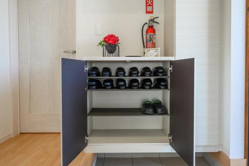 a cupboard with shoes in it in a room at 最大12人築浅物件 南部を満喫したい方に1番のおすすめ宿 無料駐車場3台 サウスウィンドハウス in Inamine