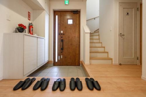 a group of shoes on the floor in a hallway at 最大12人築浅物件 南部を満喫したい方に1番のおすすめ宿 無料駐車場3台 サウスウィンドハウス in Inamine