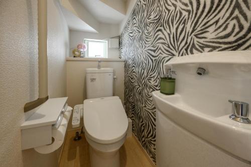 a bathroom with a white toilet and a sink at 最大12人築浅物件 南部を満喫したい方に1番のおすすめ宿 無料駐車場3台 サウスウィンドハウス in Inamine