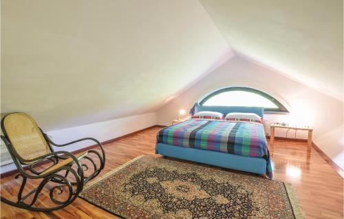 een slaapkamer met een bed en een stoel op zolder bij Relax Sport in Sermugnano