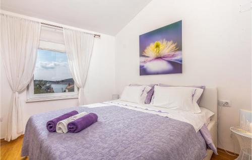 a bedroom with a bed with purple towels on it at Beautiful Home In Martinscica With Wifi in Martinšćica