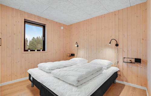 - un grand lit dans une chambre dotée de murs en bois dans l'établissement 3 Bedroom Nice Home In Rm, à Kongsmark