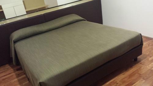 a green bed in a room with a wooden floor at La Locanda del Buon Formaggio in Tito