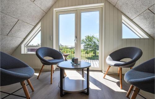 dwa krzesła i stół w pokoju z oknami w obiekcie Stunning Home In Skjern With Kitchen w mieście Skjern