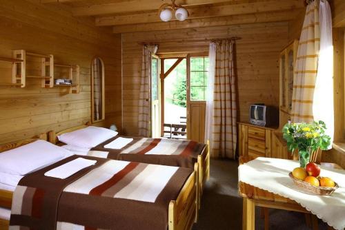 a bedroom with two beds and a table with fruit on it at Domki na Górce in Wierchomla Mała