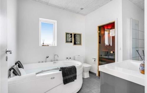 a white bathroom with a tub and a toilet at Nice Home In Haderslev With 5 Bedrooms, Sauna And Wifi in Knud