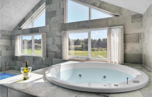 a large white tub in a bathroom with windows at Stunning Home In Stege With Sauna in Stege