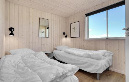 two beds in a room with a window at Stunning Home In Stege With Sauna in Stege
