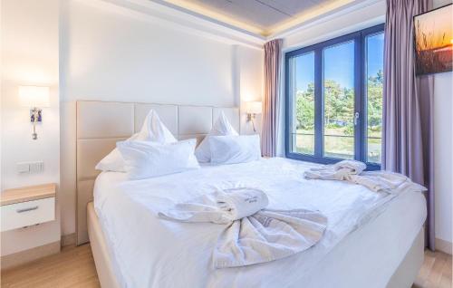 a bedroom with a white bed with a large window at Diamond in Binz