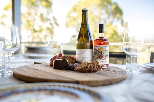 two bottles of wine sitting on a table with wine glasses at The Grove Estate in Porepunkah