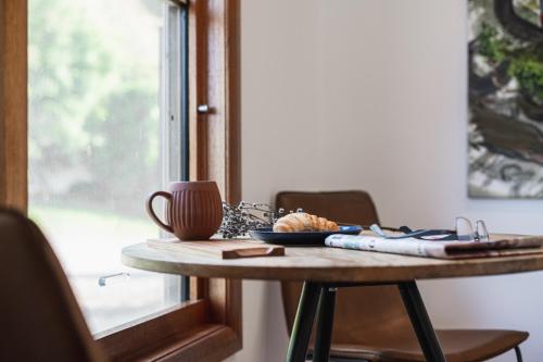 a table with a coffee mug and a cup at The Grove Estate in Porepunkah