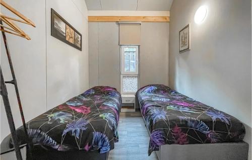 een woonkamer met 2 bedden en een raam bij 3 Bedroom Nice Home In Meijel in Meijel