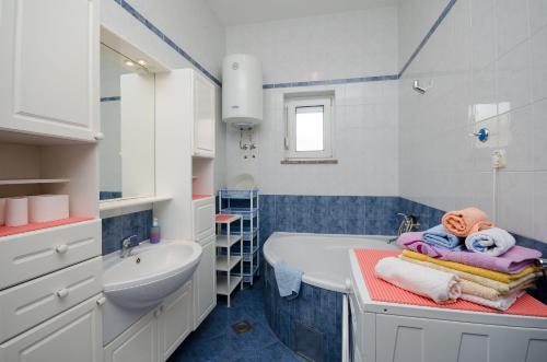 ein Badezimmer mit Badewanne und Waschbecken in der Unterkunft Apartments Mirjana in Lopar