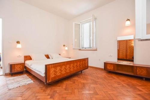 ein Schlafzimmer mit einem großen Bett und einem Fenster in der Unterkunft House Periska in Mrljane