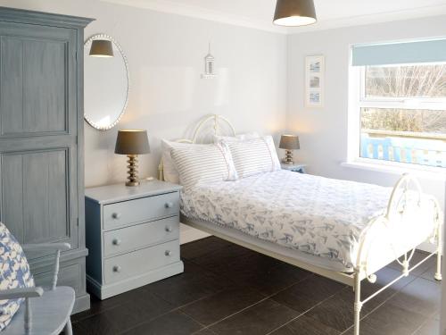 - une chambre avec un lit, une commode et un miroir dans l'établissement Sweet Briar - 8234, à Bridport