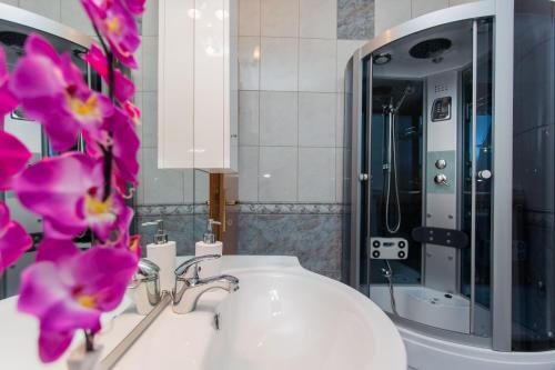 a bathroom with a sink and a mirror with purple flowers at Villa Almas in Neorić
