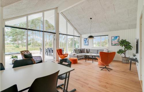 una sala de estar con una mesa y sillas en Pet Friendly Home In Nexø With Kitchen, en Neksø