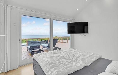 um quarto com uma cama e uma varanda com uma televisão em Nice Home In Strby With Wifi em Strøby