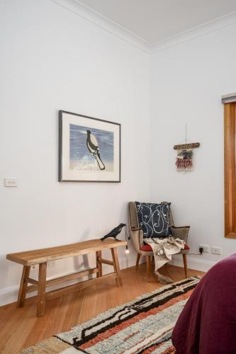 a living room with a wooden table and a chair at The Grove Estate in Porepunkah