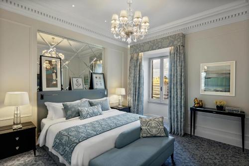 um quarto com uma cama grande e um lustre em The St. Regis Rome em Roma