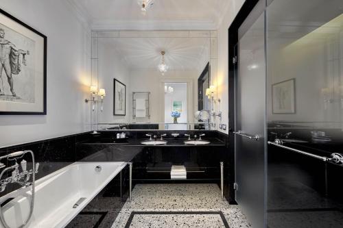 a bathroom with two sinks and a bath tub at The St. Regis Rome in Rome