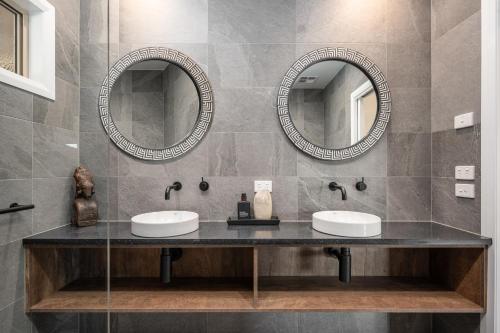two sinks in a bathroom with two mirrors at The Grove Estate in Porepunkah