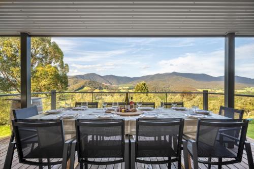 a dining room with a table and chairs and a large window at The Grove Estate in Porepunkah