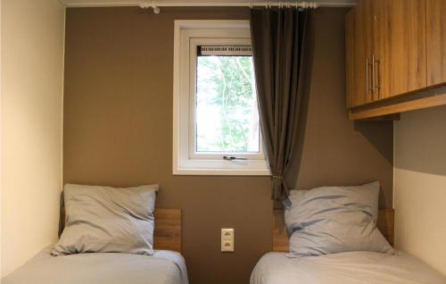 - une chambre avec 2 lits et une fenêtre dans l'établissement Chalet 34, à Oosterwolde