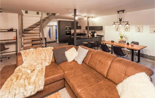 a living room with a brown couch and a kitchen at 2 Bedroom Beautiful Home In Ulrichstein in Ulrichstein