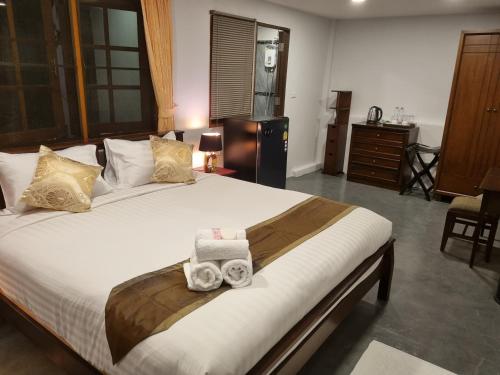 a bedroom with a large bed with two towels on it at Meyers Hua Hin in Hua Hin