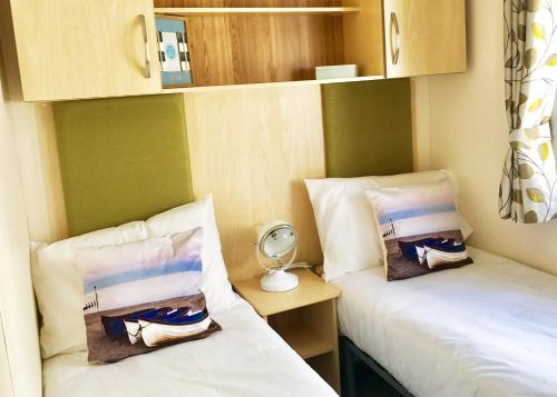 two beds sitting next to each other in a room at Mersea Island Holiday Park in East Mersea