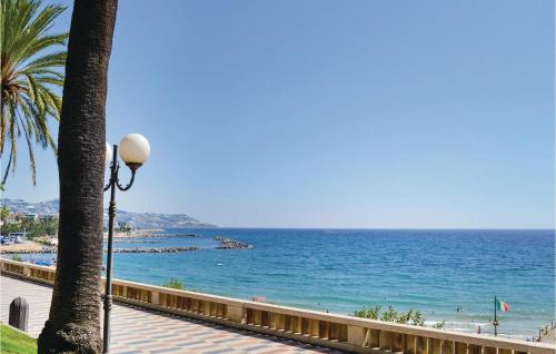 a view of a beach with a palm tree and a street light at Chez Gaby in Borghetto San Nicolò