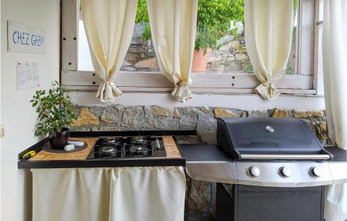 a kitchen with a stove and a window at Chez Gaby in Borghetto San Nicolò