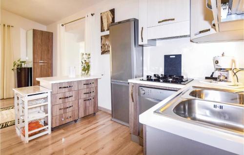 a kitchen with a sink and a stainless steel refrigerator at Chez Gaby in Borghetto San Nicolò