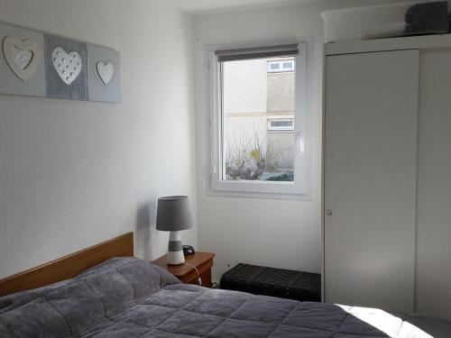 um quarto com uma cama e uma janela em Appartement Balaruc-les-Bains, 2 pièces, 2 personnes - FR-1-680-12 em Balaruc-les-Bains