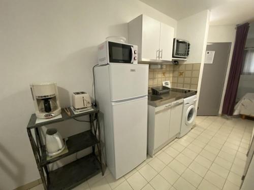 Il comprend une cuisine équipée d'un réfrigérateur et d'un lave-linge/sèche-linge. dans l'établissement Appartement cosy avec terrasse à Balaruc-les-Bains, proche thermes, équipé, animaux acceptés - FR-1-680-28, à Balaruc-les-Bains