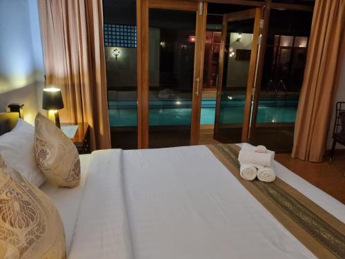 a bedroom with a bed with two rolled towels on it at Meyers Hua Hin in Hua Hin