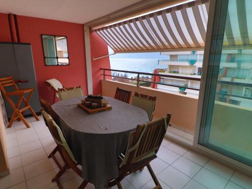 une salle à manger avec une table et une vue sur l'océan dans l'établissement Charmant T2 climatisé avec loggia et cabine à Sète - FR-1-472A-267, à Sète