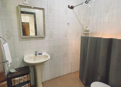 a bathroom with a sink and a toilet and a mirror at VILLA PRAIA GRANDE in Matinhos